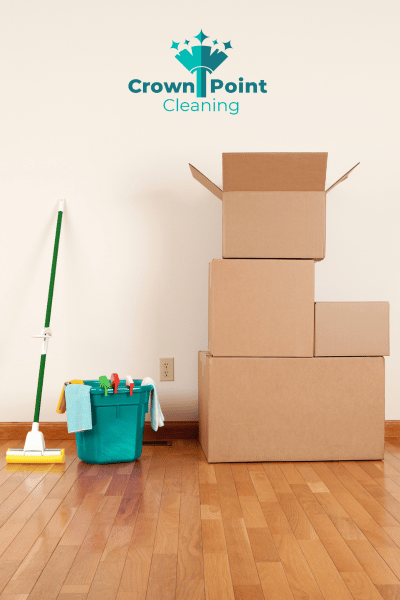 Cleaning supplies sitting next to moving boxes in the empty home, ready to be used for a move-in, move-out clean.